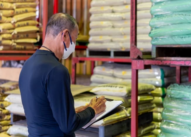 管理棚の前で記録を行う毛利産業のスタッフ